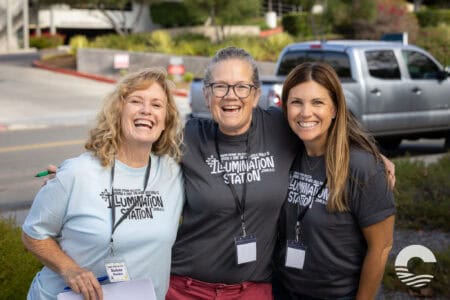 Three smiling women volunteers at Canyon Springs Church event.