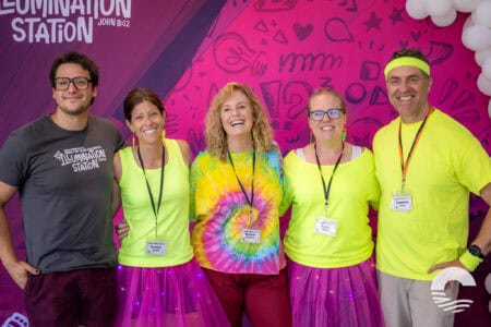 Group of smiling people at Canyon Springs Church event in colorful attire.