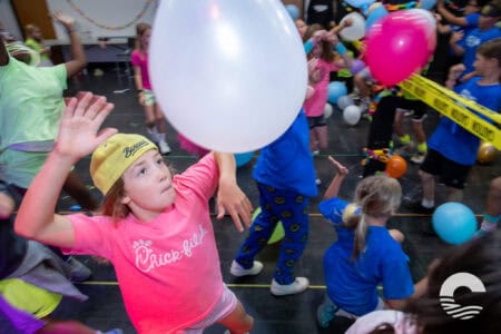 Children enjoying a balloon activity at Canyon Springs Church event.
