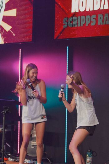 Two young women singing and having fun on stage at Canyon Springs Church youth event.