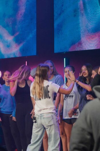 Group of teenagers participating in a youth worship night at Canyon Springs Church.