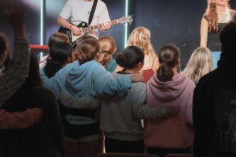 A group of young people gathered together during a worship session at Canyon Springs Church, engaging in faith and community. Youth group worship session at Canyon Springs Church with music and community.