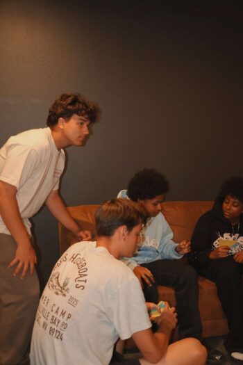 Group of diverse teenagers sitting and talking in a church lounge.