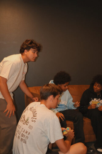 Teenagers engaged in a discussion during a youth group meeting at Canyon Springs Church. Group of diverse teenagers sitting and talking in a church lounge.