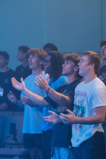Group of diverse young people worshiping at Canyon Springs Church.