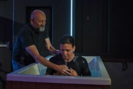 A man is baptized in water during a church baptism ceremony at Canyon Springs Church, symbolizing faith and spiritual renewal. Person being baptized in water during church baptism service at Canyon Springs Church.