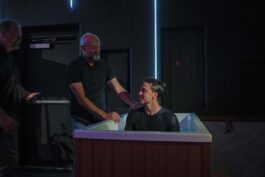 A young man is baptized in a church baptismal, symbolizing faith and spiritual renewal at Canyon Springs Church. Person being baptized in a church baptismal with pastor and attendees present.