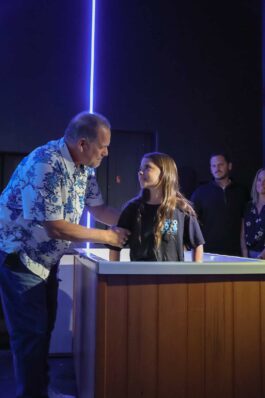 A man and a young girl share a handshake during a community event at Canyon Springs Church. Man and girl shaking hands at Canyon Springs Church youth event.