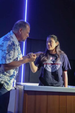 A man and a young woman exchange a handshake during a youth event at Canyon Springs Church, highlighting community and faith. Man and young woman shaking hands at Canyon Springs Church youth event.