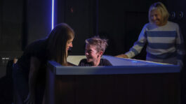 Church reception area with friendly staff welcoming visitors. A woman and a young boy smiling and talking at a church reception desk.