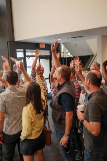 People raising hands in worship at Canyon Springs Church event.